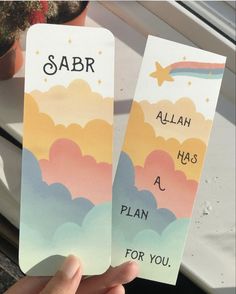 someone holding up two bookmarks that say sabr and aah has a plan for you