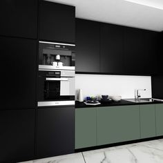 a black and white kitchen with marble counter tops, cabinets, and an oven on the wall