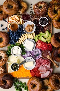 an assortment of different types of doughnuts on a tray with dips and fruit