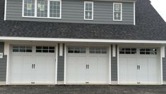 three garage doors are open in front of a house