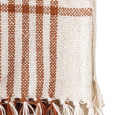 an orange and white striped blanket with tassels