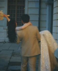 a man and woman are walking down the street with bags on their back as they hold each other's hands