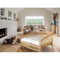 a living room filled with furniture and a fire place next to a window on top of a hard wood floor