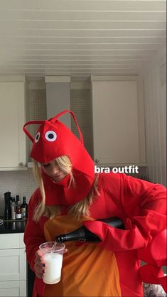 a woman in a red lobster costume holding a drink