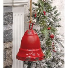 a red bell hanging from the side of a christmas tree