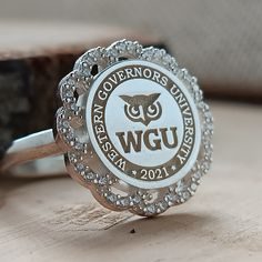 You can send all your questions about my store and products via message. In this description, all the details of the product are explained to you. *The logo of any university you want can be made. * Ring Face: Round *We can use the stone colors you want in the ring. *I can make our rings in 10K, 14K, 18K and 22K gold. *The ring is 925 Sterling Silver. *We can change the color of the stone in the ring. All colors are available. *The ring has My Brand and 925K stamps on it. *Before the rings are p Elegant Engraved Cluster Ring As A Gift, Elegant Engraved Cluster Ring For Gift, Engraved White Diamond Ring For A Gift, White Gold Signet Ring With Halo Setting As Gift, Silver 14k Gold Cluster Promise Ring, Silver Engraved Ring With Halo Setting As Gift, White 14k Stamped Engraved Ring Gift, White 14k Stamped Engraved Ring As A Gift, Silver 14k Gold Halo Ring For Anniversary