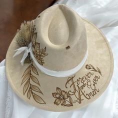 Burned Wide Brim Bridal focused Hat in Antique Beige, but also available in other shades of white. This Hat is burned using pyrography techniques. Embellishments with Rhinestones used for some bling and brightness. Dried Flowers and chiffon ribboning for the band details. Add your Date, initials and anything else youll want on your Forever Hat. Custom Adjustable Wedding Hats, Bohemian Wedding Hat With Adjustable Fit, Bohemian Adjustable Wedding Hat, Bohemian Adjustable Hat Bands For Wedding, Pyrography Techniques, Velvet Hat, Shades Of White, Wide Brimmed Hats, Brim Hat