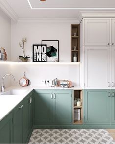 a kitchen with green cabinets and white counter tops, an area rug on the floor