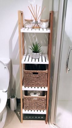 a bathroom with a toilet, shower and shelf filled with baskets next to the toilet