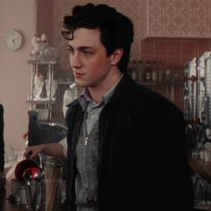 a man standing in front of a counter with a blender