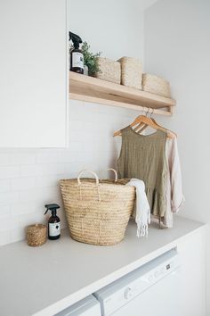 a laundry room with white walls and open shelving