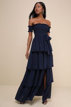 a woman wearing a blue dress with an off the shoulder top and tiered skirt