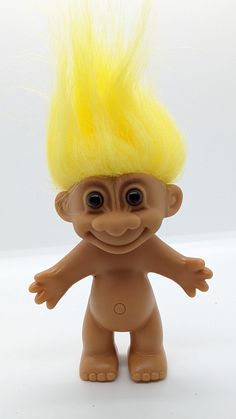 a toy troll with yellow hair on it's head