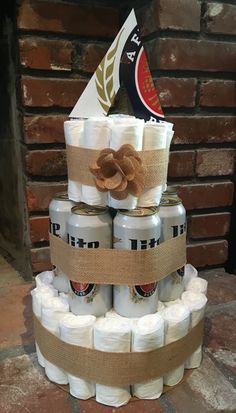 a cake made out of beer cans and burlocks with a bow on top