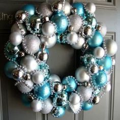 a blue and white christmas ornament wreath hanging on a front door with silver ornaments