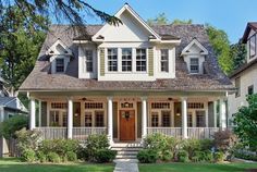 a large white house with lots of windows on it's front porch and landscaping