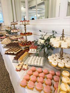 a table filled with lots of different types of desserts and pastries on it