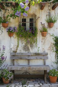 a wooden bench sitting in front of a wall covered with potted plants and flowers