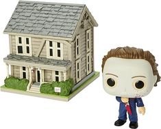 a figurine is shown next to a house with a zombie face on it