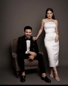 a man in a tuxedo sitting next to a woman in a white dress