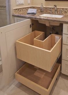 an open drawer in the middle of a bathroom sink