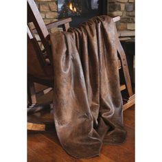 a chair with a blanket on it next to a fire place