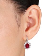 Elegant and sophisticated, these drop earrings are perfect for that special event or occasion. Fashioned in sleek sterling silver, these drop earrings showcase 9.0 x 7.0mm oval-shaped lab-created red ruby center stones. Starburst borders of lab-created white sapphire accents frame the center stones, while shimmering diamond accents adorn the earring's front. A magical look she'll turn to often, these earrings are polished to a brilliant shine and suspend from and secure with lever backs. Elegant Oval Pendant Earrings For Anniversary, Oval Pendant Earrings For Wedding, Elegant Sterling Silver Oval Pendant Earrings, Teardrop Halo Setting Earrings, White Gold Oval Earrings, Leverback Earrings, Red Ruby, White Sapphire, Sapphire Diamond