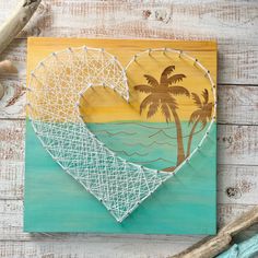 a string art heart with palm trees on the beach