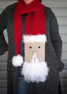 a woman wearing a knitted santa hat and scarf with white pom - poms