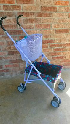 a baby stroller with a basket on the handlebars is shown in front of a brick wall