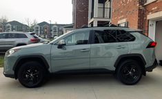 a gray jeep parked in front of a brick building