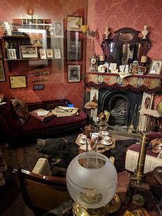 a living room filled with furniture and a fire place next to a wall covered in pictures