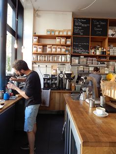 a man standing at a counter in a coffee shop