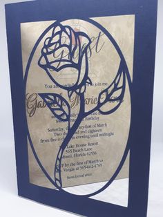 a blue and white wedding card with a rose on it's front, in the shape of a circle