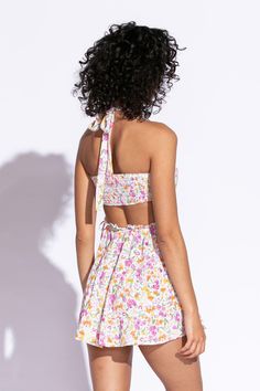 STYLE INFORMATION: Get your Texas boho vibes on in the Sundown Wildflower Floral Print Sundress!. Wildflower floral print, in hues of pink, orange, green, and yellow shapes this cute dress that has a halter V-neckline with tie straps, and a cutout waist.. The open back wraps around to the sides to create a cutout effect above the attached mini skirt. Ruffle trim and side ties decorate the cutout waist. DETAILS & CARE: Rayon/Polyester. Dry Clean. Imported. SHIPPING: We offer free shipping for all Sundress Boho, Halter Sundress, Floral Print Sundress, Skirt Ruffle, Boho Pink, Lemon Print, Halter Mini Dress, Boho Vibe, Ruffle Trim