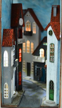 there is a miniature model of a town with lights on the windows and buildings in the street