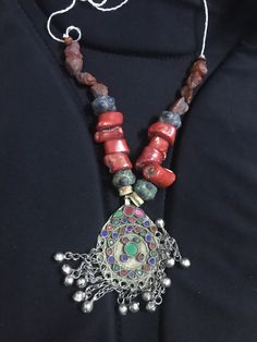 A vintage Amazigh Berber silver pendant tribal necklace from the Draa valley region of the anti Atlas Mountains Morocco.  The tribal necklace has a antique pendant ancient glass on pendant and is strung with old African trade beads including coral, abnormal agate shape stones with unique design from the best artitian Traditional Gemstone Beaded Round Pendant, Traditional Round Pendant Jewelry With Gemstone Beads, Bohemian Medallion Jewelry With Natural Stones, Bohemian Medallion Necklace With Natural Stones, Traditional Necklaces With Natural Stones And Round Pendant, Traditional Necklace With Natural Stones And Round Pendant, Traditional Round Pendant Necklace With Natural Stones, Bohemian Necklace With Polished Round Pendant Beads, Traditional Jewelry With Round Pendant Natural Stones