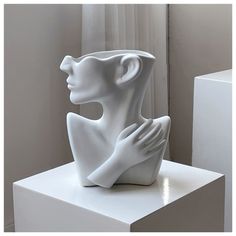 a white sculpture sitting on top of a table next to a window