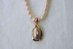 This enhancer consists of an oval shaped Japanese Mabe pearl. The Mabe pearl itself is approximately 1/2 inch tall by 7/16 inch wide. It has a pink overtone with very high luster. It's all made in 14K yellow gold. The total length from the top of the bail to the bottom is approximately 1.25 inches long and 5/8inch wide. **This enhancer DOES NOT come with a chain and DOES NOT come with the pearl necklace** You will ONLY receive the enhancer. You can wear this with any chain, pearl necklace or any Oval Yellow Gold Pearl Chain Necklace, Formal High Luster Pearl Pendant Necklace, Formal Oval Pearl Chain Jewelry, Oval Akoya Pearl Necklace With Pearl Pendant, Classic Gold Oval Pearl Necklace, Elegant Teardrop Pearl Necklace With High Luster, Classic Oval Gold Pearl Necklace, Yellow Gold Oval Pearl Necklace, Classic Oval Yellow Gold Pearl Necklace