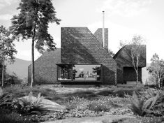 a black and white photo of a house in the woods