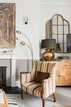 a living room filled with furniture and a fire place in front of a painting on the wall