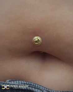 a close up of a person's stomach with a gold ring on it