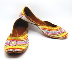 Ethnic Indian/Pakistani style shoes durable and hand stitched with genuine leather sole and leather padded cushion inside. These beautiful pair in white offers hand embroidery with Rainbow colorful pearls, sequence, rhinestones and beads gives is a very extra ordinary look while maintaining its simplicity.  The simple design goes good with any colored outfits. They offer comfort and style, while still looking fabulous in these. Perfect or brides or everyday outfits. We offer many different designs of shoes to choose from. See our page for more of our collection! We ship out in a timely matter, wrapped in care for a safe secure trip to your location. Thank you for supporting our small business! Shipped from USA. Sizes available US 6,7,8,9,10. Handwork Flats For Summer Festival, Traditional Flats With Dori Work For Summer, Summer Festival Flats With Handwork, Closed Toe Flats With Handwork For Summer, White Closed Toe Flats For Festivals, Traditional Closed Toe Summer Flats, Traditional Closed Toe Flats For Summer, Traditional Summer Festival Flats, Festive White Round Toe Flats