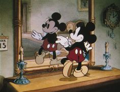 mickey and minnie dancing in front of a mirror