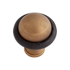 an antique brass and black knob on a white background