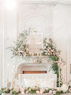 an elegant fireplace mantel decorated with flowers and candles