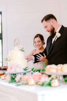 a bride and groom are cutting their wedding cake at the end of the reception table