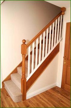 the stairs are made of wood and have white balustiers on them, along with carpeted flooring