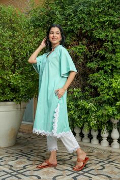 Dusty jade kurtapant set is perfect for a festive season or a day out .Cotton cambric fabric makes it perfect for summer weather. Front v-neckline kurta with lace detail bell sleeves give a classic look. Product has no lining. Pant has two side pockets, back elasted waistband and lace on the hem. Cold wash and Dry clean only.Type of Work: Solid Fit: Loose Model Height: 5'7 Measurements: Kurta-36.5" Pant- 34" SKU#: 11702071GR Disclaimer: There may be slight difference in actual product color comp Cotton Lace Trim Sets With Short Sleeves, Cotton Sets With Lace Trim And Short Sleeves, Festive V-neck Kurta For Summer, Summer Festive V-neck Kurta, Cotton V-neck Kurta For Summer, Summer Cotton Kurta With V-neck, Cotton Short Sleeve Sets With Lace Trim, Festive Summer V-neck Kurta, Cotton V-neck Set For Eid