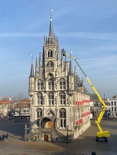 a large building with a crane on it's side in the middle of town